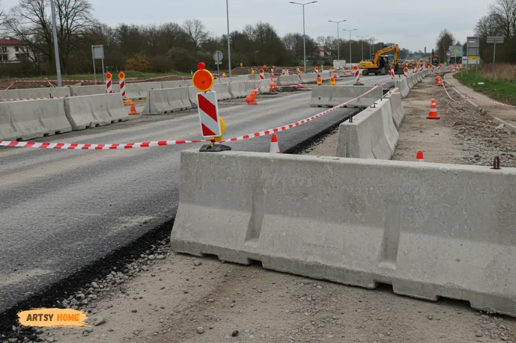 Realistic photo of heavy-duty concrete Jersey barriers along a busy road construction site.