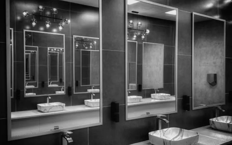 Modern bathroom with large mirrors and marble sinks.