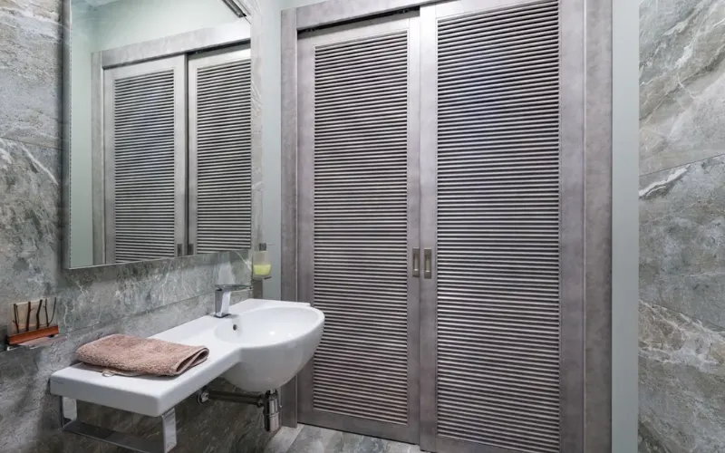 Bathroom with floating sink and grey louvered closet doors